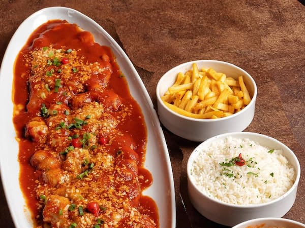 Parmegiana coberta com molho e queijo, acompanhada de arroz e batatas
