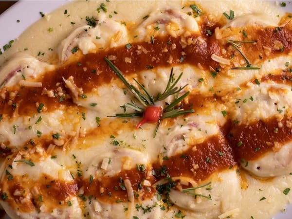 Rondelli recheado, coberto com molho e queijo gratinado